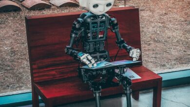 artificial intelligence (ai) berbentuk robot yang sedang duduk sambil memainkan tabnya